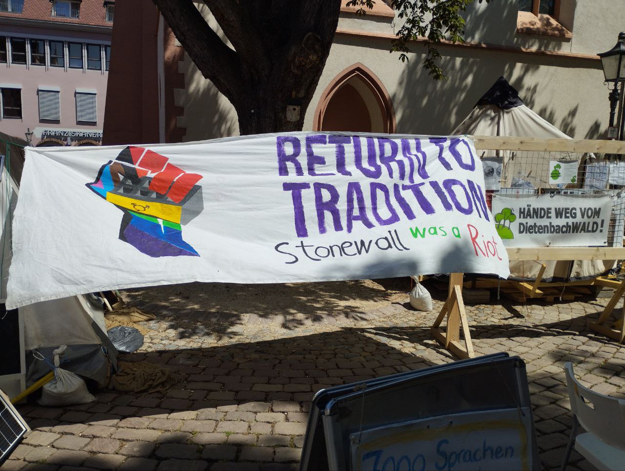 Regenbogenfaust und der Text "Return to Tradition - Stonewall was a Riot"